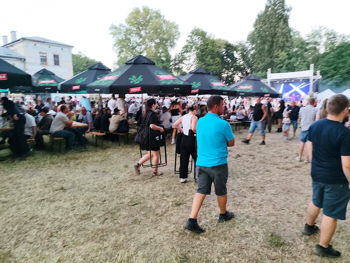 Parasole i stoiska Szewczyk Grill przed sceną koncertową podczas imprezy plenerowej