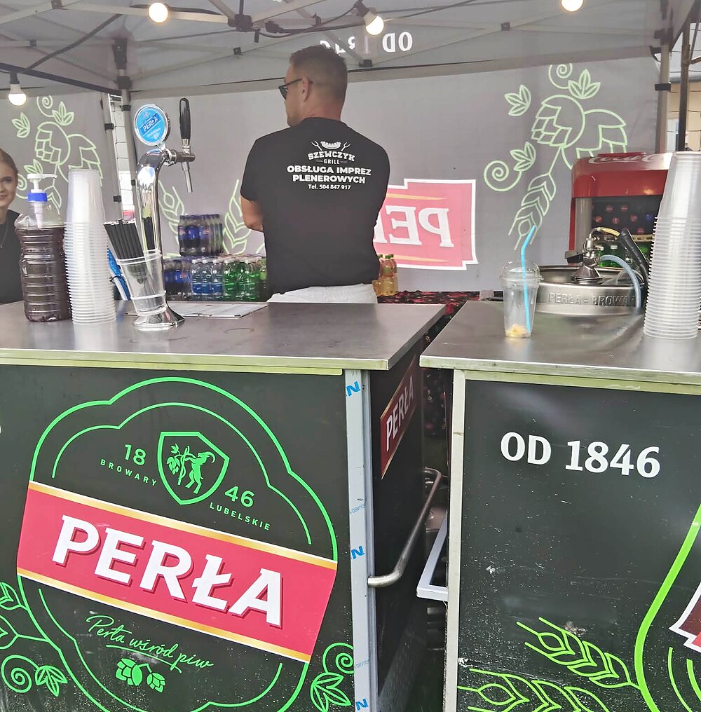 Obsługa stoiska z napojami w koszulce z logo Szewczyk Grill obsługa imprez plenerowych